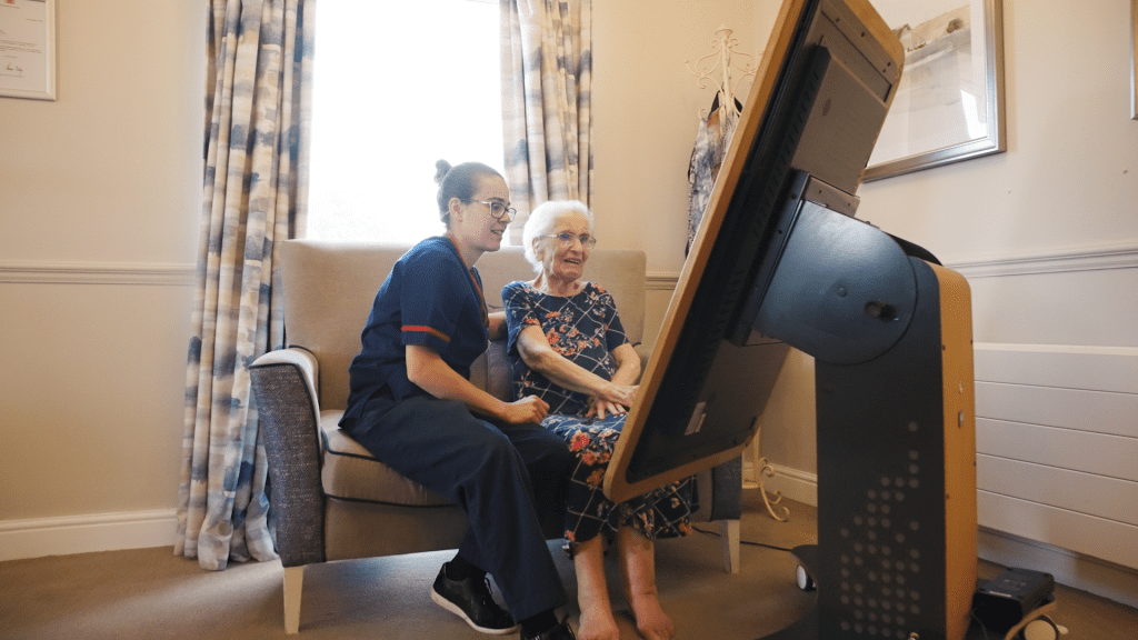 Carer using tablet with elderly resident